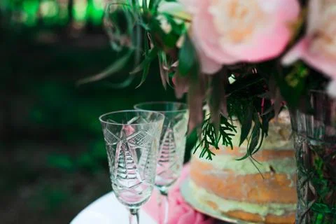 Two glasses on the table on the background of flowers and cake. wedding ceremony Stock Photos