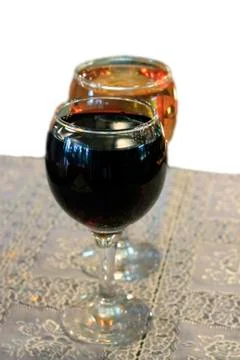 Two glasses on the table with a white tablecloth isolated on the white backgr Stock Photos