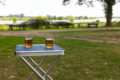 Two glasses of tea outside on a table on the river Maas Stock Photos