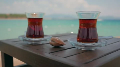 Two glasses of turkish tea on the table with Mediterranean Sea on the background Stock Footage 53121059