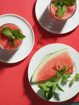 Two glasses of water melon red fresh smoothie on red table. Overhead shot. Stock Photos