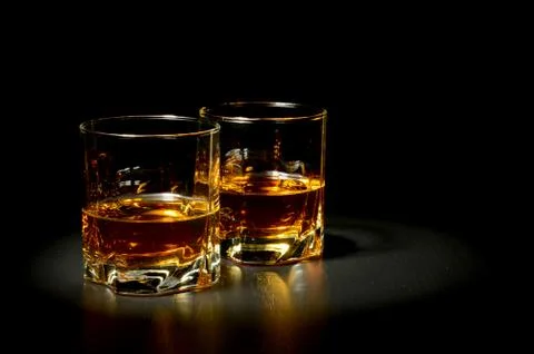 Two glasses of whiskey on black table Stock Photos