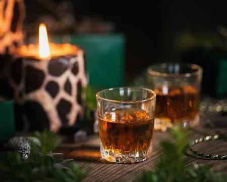 Two glasses of whiskey or bourbon with Christmas decoration Stock Photos