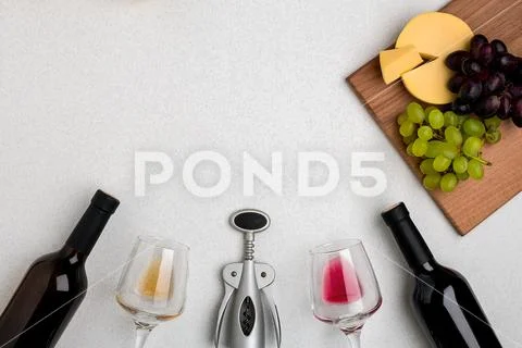 Two glasses of white and red wine, cheese and grapes. Top view Stock Photos