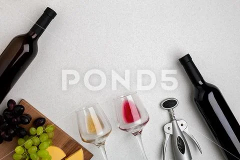 Two glasses of white and red wine, cheese and grapes. Top view Stock Photos