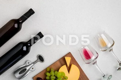 Two glasses of white and red wine, cheese and grapes. Top view Stock Photos