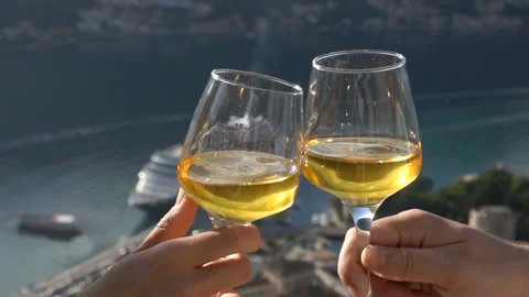 Two glasses of white wine touch each other on the background of the bay Stock Footage 120754813
