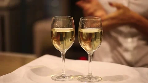 Two glasses of white wine on a tray Stock Footage 62196399