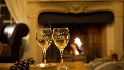 Two glasses of wine against the backdrop of a burning fireplace Stock Footage 107730004