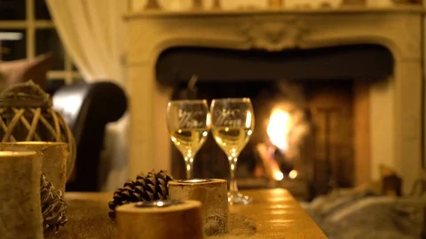 Two glasses of wine against the backdrop of a burning fireplace Stock Footage 107730435