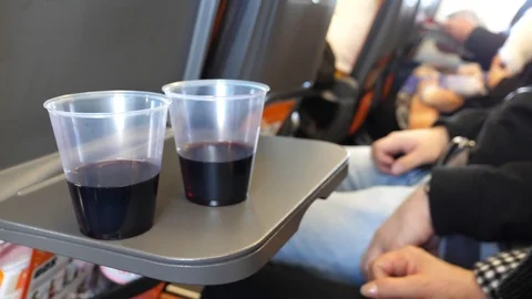 Two glasses of wine on aircraft tray table Vídeos de archivo 106950497