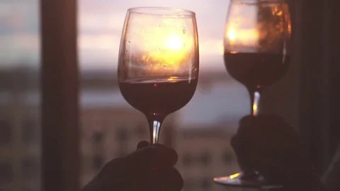 Two glasses of wine are drawn to each other against the backdrop of a window Stock-Footage 80088994