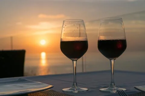 Two glasses of wine on the background of the setting sun Stock Photos