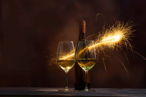 Two glasses with wine bottle circled with fire work. Stock Photos