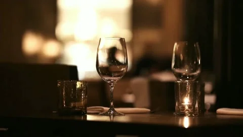 Two glasses of wine on a restaurant table by the light of a small candle burning Stock Footage 158834840