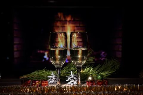 Two glasses with wine on the table against the background of the fireplace. Stock Photos
