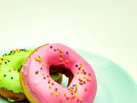 Two glazed donuts on a blue plate Stock Photos