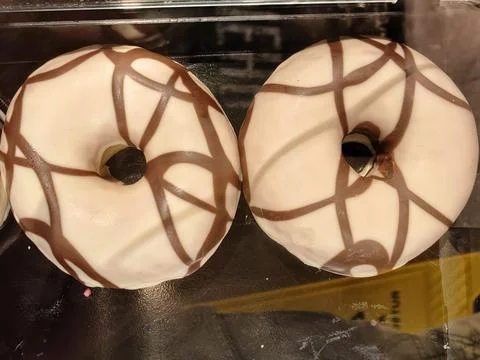 Two glazed donuts with chocolate drizzle Stock Photos