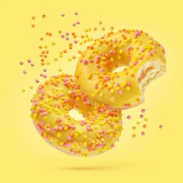 Two glazed donuts on yellow background. Stock Photos