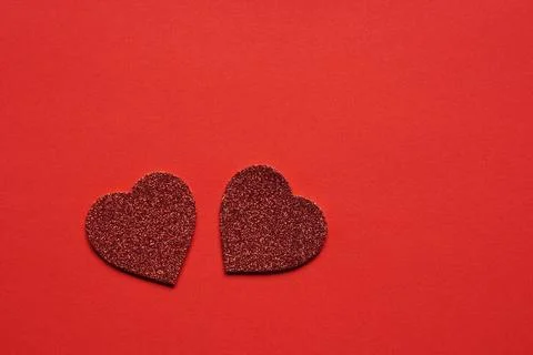 Two glitter hearts on red background two heart shaped glitter hearts on re... Stock Photos