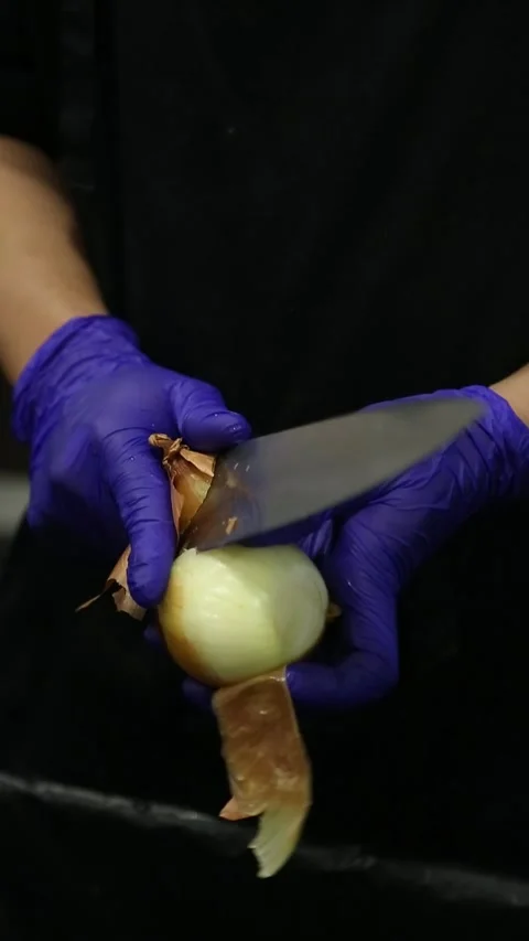 Two gloved hands holding an onion and a knife. Suitable for cooking, Stock Footage 311017790