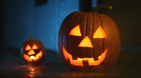 Two glowing jack-o-lanterns sit on a porch while eerie smoke passes around them 스톡 동영상 30562074