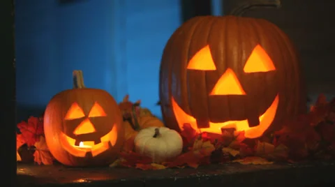 Two glowing jack-o-lanterns sitting on a porch with eerie smoke, slider push in Stock Footage 30562688