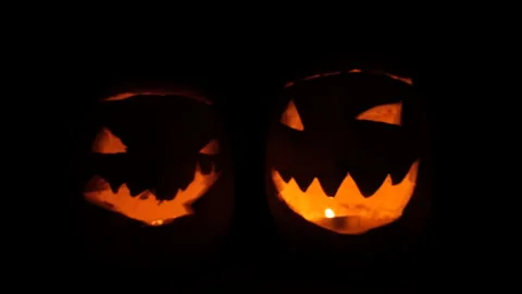 Two Glowing Jack-o'-Lanterns with Flickering Candles in Darkness Stock Footage 342563043
