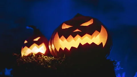 Two glowing lanterns are orange-blue scary pumpkins with smoke forest. Stock Footage 162547049