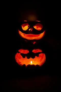 Two glowing pumpkins with faces in the dark Foto stock