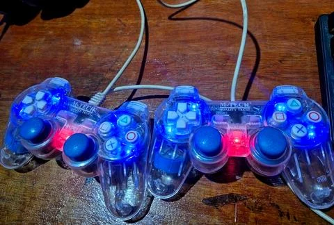Two glowing USB gamepads on desk Foto stock