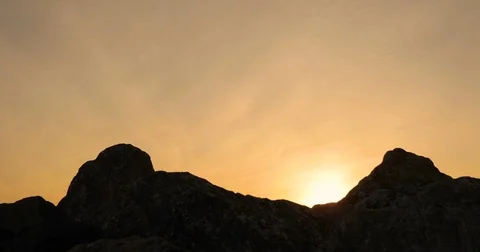 Two go on rocks, against a sunset Stock Footage 74750186