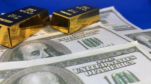 Two gold bars displayed on one-hundred-dollar banknotes, Stock Photos