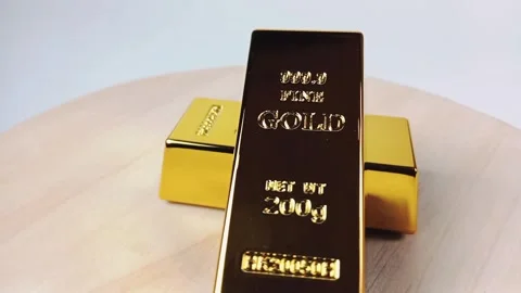 Two gold bars rotating on a wooden base Stock Footage 329081006
