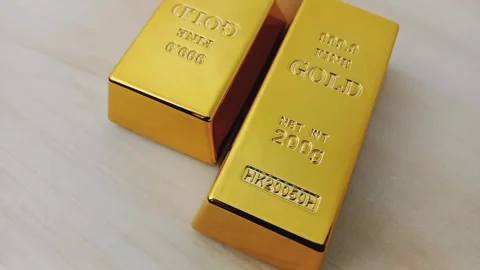 Two gold bars rotating on a wooden base Stock Footage 329081029
