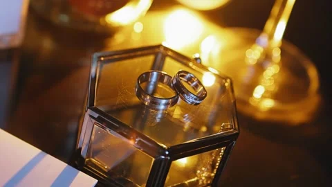 Two gold rings are lying on a glass casket. Shooting jewelry up close Stock Footage 340329245