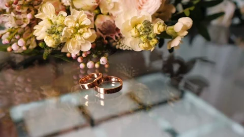 Two gold wedding rings lie on a glass table Stock Footage 121925133