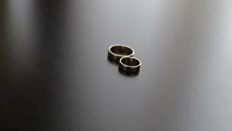Two gold wedding rings lying on a table Stock Footage 102172639