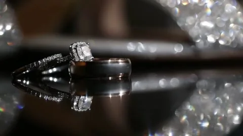 Two gold wedding rings lying on a table shining with light close up Stock Footage 190462670