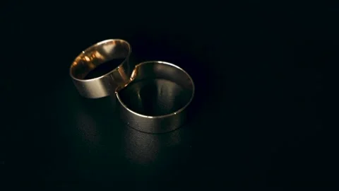 Two gold wedding rings rotate on a black... | Stock Video | Pond5