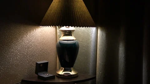 Two gold wedding rings stand in a box under a table lamp on in a dark room. Stock Footage 163098294
