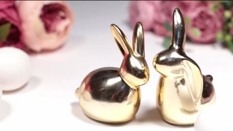 Two golden rabbits behind white background with flowers Stock Footage 170751208