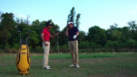 Two golfers are talking on the training ground  Stock Footage 129171542