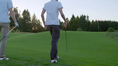 Two golfers walk to the putting green Stock Footage 60199079