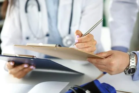 Two GP examining test results clipped to pad Stock-Fotos