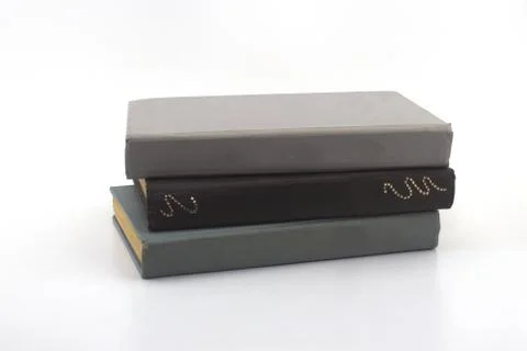 Two gray and one brown old books on a white background Stock Photos