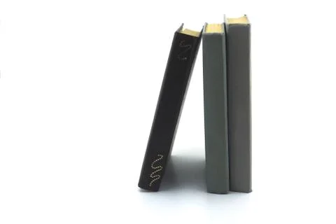 Two gray and one brown old books standing on a white background Foto stock