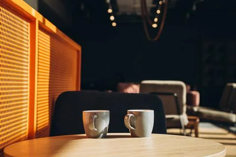 Two gray cups in the interior of a sunny cafe in the morning. Foto stock