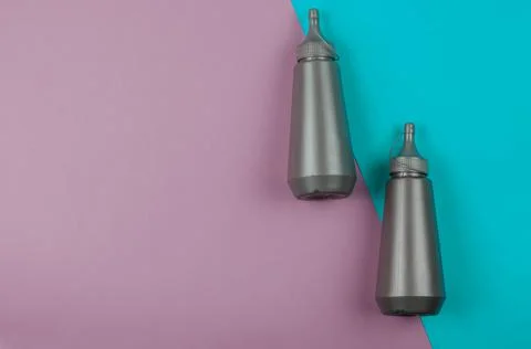 Two gray plastic bottles on a pink and turquoise background. Stock Photos