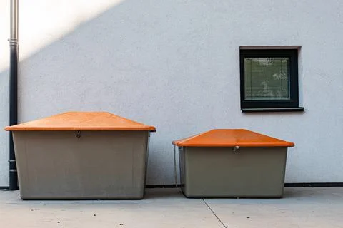 Two gray plastic boxes with an orange lid for storing sand, salt for janitori Stock Photos